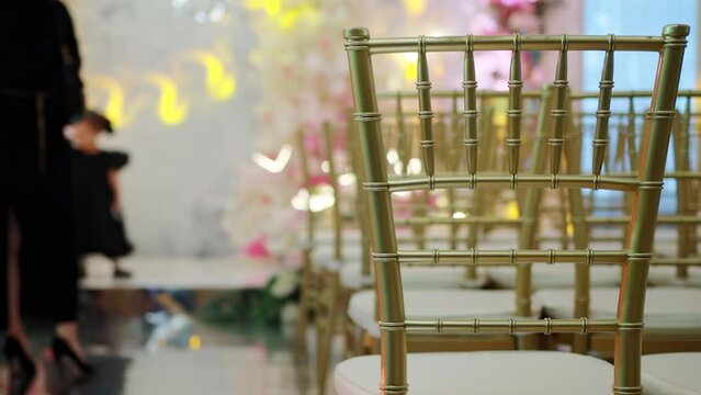 several rows of chairs in the gala hall with guests in the background before the start of the holiday. The beginning of the festive event. Slow motion