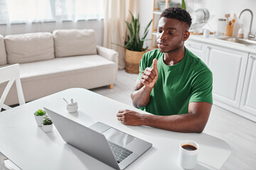 deaf african american man using sign language for online communication on laptop, video chat