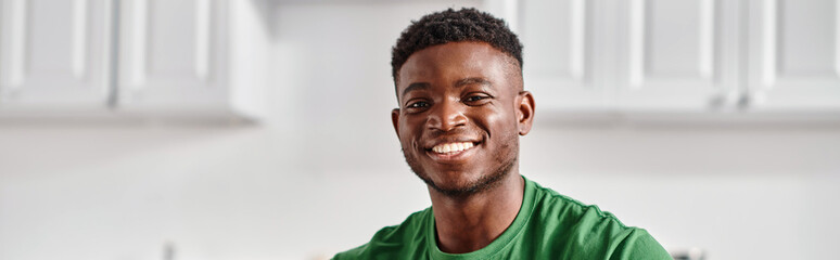 portrait of cheerful african american man smiling while looking at camera, horizontal banner