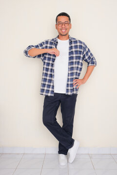 Full body portrait of a man lean on something with happy expression