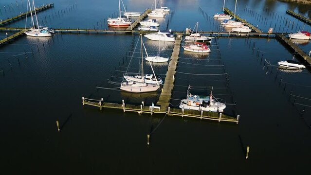 Idyllische Bootsanlegestelle am ruhigen See mit malerischen H&auml;usern im Hintergrund. Drohnenaufnahme. Marina Fisken&aelig;s, Fisken&aelig;svej, Gr&aring;sten, D&auml;nemark