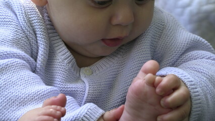 Infant putting foot in mouth and regurgitating vomiting milk