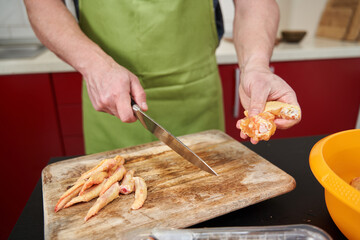 Man cook cutting chicken wings