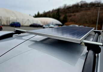 traveler has a solar panel on the roof racks on the roof of the small camper van. Very simply, he...