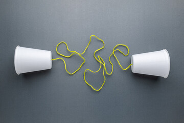 Two paper white cups with confused string, complicated, confused, two way communication