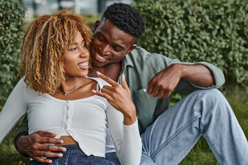 cheerful african american woman in braces using sign language for communication with boyfriend