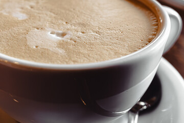 A large white cup with a coffee drink. A large cappuccino. An invigorating drink. Cheerful morning....