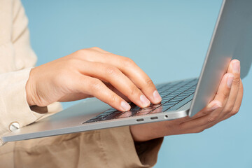 Portrait of African American woman, programmer, copywriter typing on keyboard, using laptop