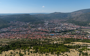 Elevated view of Mostar surrounded with mountains, sunny summer day