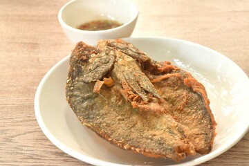 deep fried black-banded trevally fish on plate dipping spicy chili sauce  
