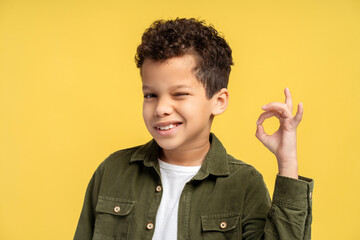 Attractive, handsome African American boy wearing stylish casual clothes showing ok gesture, winking © Maria Vitkovska