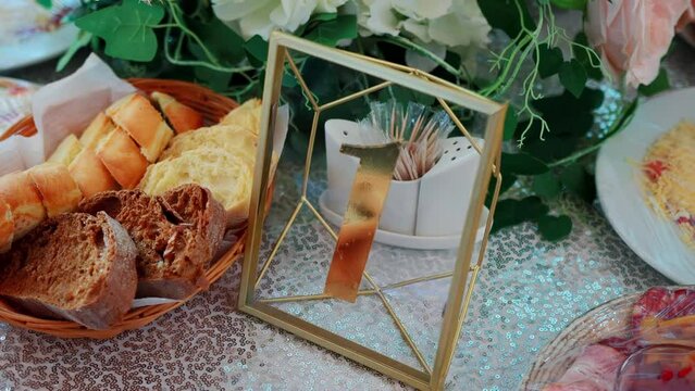 A plate with the number one on a festive table with food in a restaurant, slow motion, background