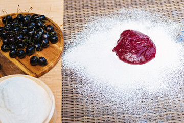 A bowl of cherries next to a bowl of powdered sugar. Mochi asian dessert