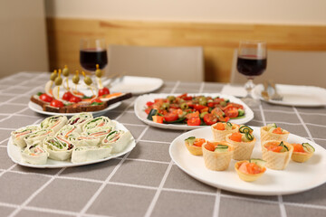 Red wine is poured into a glass on a table with festive dishes