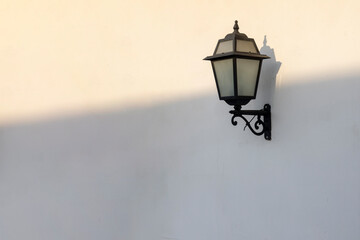 vintage black street lamp on white wall with dawn line