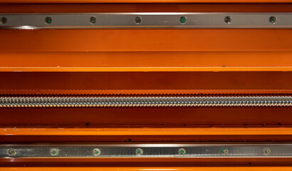 metal elements of a CNC machine in orange color
