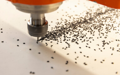 CNC milling of a composite aluminum cassette using a cutter, black small chips
