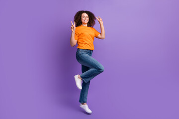 Fototapeta na wymiar Photo of positive adorable crazy woman wear stylish orange clothes demonstrate v-sign isolated on purple color background