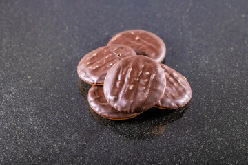A close up view of chocolate biscuits on a dark marble platter