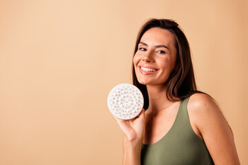No retouch photo of gorgeous adorable woman hold brush dry anti cellulite massage procedure empty space isolated on beige color background - obrazy, fototapety, plakaty