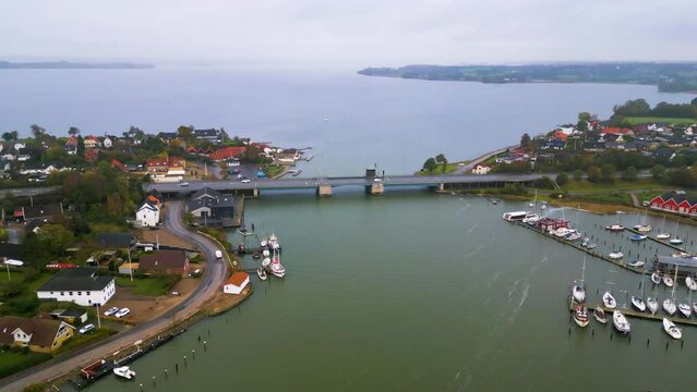 Luftaufnahme einer Kleinstadt am Fluss mit einer Zugbr&uuml;cke und Booten am Anleger. Egernsundbr&uuml;cke in Egernsund, D&auml;nemark.