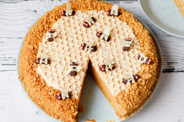 Honey cake with honeycombs and chocolate bee, flat lay. Top view.