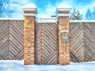 A new gate, entrance to a private territory on a winter day and snow. Metallic texture and...