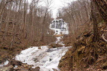 Amicalola waterfalls is frozen in winter. Snow has fallen on the lakes and waterfalls. The majority of water surface is sleek. Icicles, ice are everywhere in this state park. Many visitors enjoy views