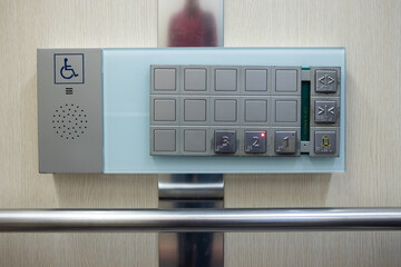 braille signage on elevator buttons on the wooden wall. elevator buttons with number and braille...