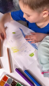 Youthful artistic imagination, childhood hobby. Little boy and girl engage in creative drawing with colored pencils, fostering creativity indoors amidst art supplies, pictures and indoor houseplants