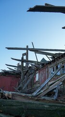 Naklejka premium Red Barn On Midwest Farm Fallen Boards And Debris Due To Heavy Rain And Snow