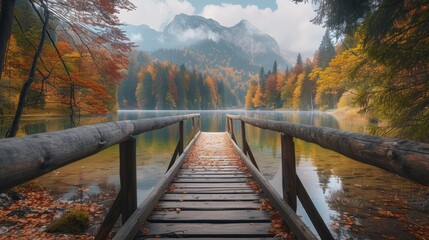a wooden bridge over a body of water surrounded by a forest filled with colorful trees and a mountain range in the distance. - obrazy, fototapety, plakaty
