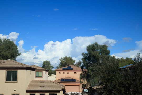 Arizona typical residential house tile roofs under slowly rising dense cumulus clouds in winter