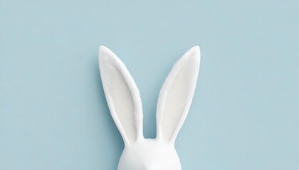 White rabbit ears with tan inner detail on a pastel blue background.