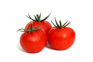 Three red tomatoes lie on a white background.	