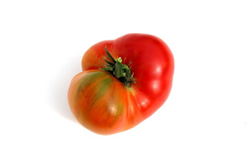  A ragged red tomato lies on a white background.