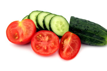  Sliced fresh cucumbers and tomatoes lie on a white background