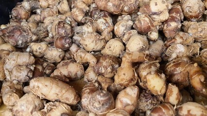 Close up pile of tasty fresh ginger sold at the market as a background.