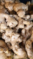 Close up pile of tasty fresh ginger sold at the market as a background.