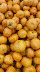 Close up pile of tasty fresh oranges sold at the market as a background.