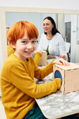 Portrait of a red-haired boy during classes with a child development specialist. Pediatric speech and language therapy