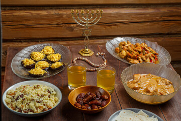 Shabbat table for a family meal with traditional holiday dishes on the table with a rosary