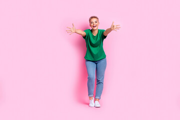 Full size photo of cheeful friendly girl dressed green t-shirt jeans stretching arms to embrace you...