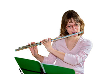 A young female flautist plays a wind instrument flute and looking at the notes, isolated on a white...