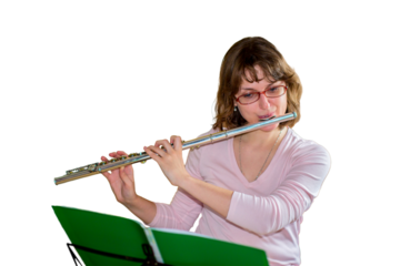 A young female flautist plays a wind instrument flute and looking at the notes, isolated on a white background