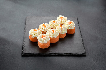 Deluxe Philadelphia rolls wrapped in salmon and topped with a dollop of cream cheese, a luxurious sushi treat