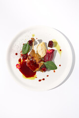Duck leg confit with berry sauce on a white background, top view - a gourmet delight for fine dining establishments