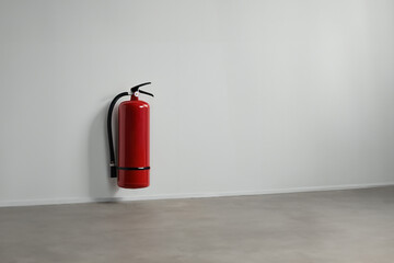Fire extinguisher install on the white wall.