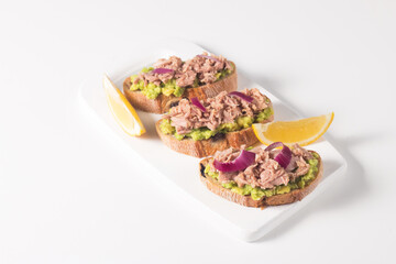 Toast with Canned Tuna. Fish open sandwich with avocado, red onion and lemon. 