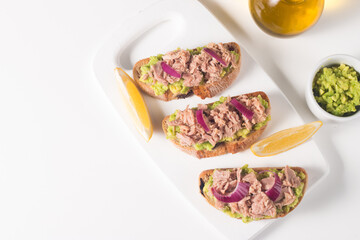 Toast with Canned Tuna. Fish open sandwich with avocado, red onion and lemon. 